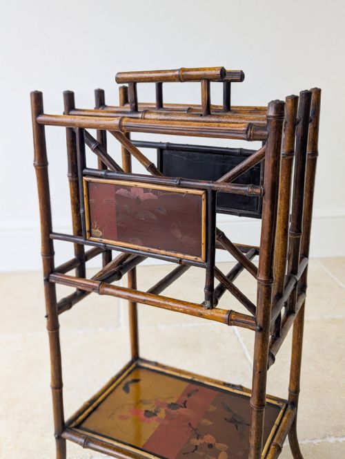 fig 1. Victorian Aesthetic Movement dark brown bamboo canterbury with vertical compartments, lacquered decorative panels, and a lower open shelf.