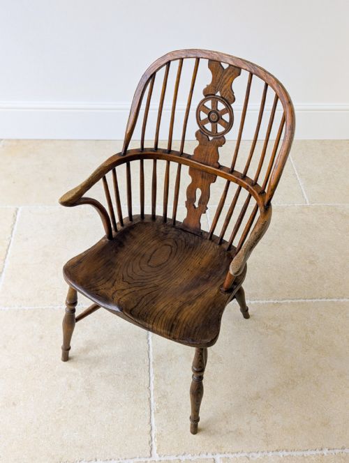 fig 1. A George III period ash and elm wheelback Windsor armchair with turned legs and a shaped saddle seat.