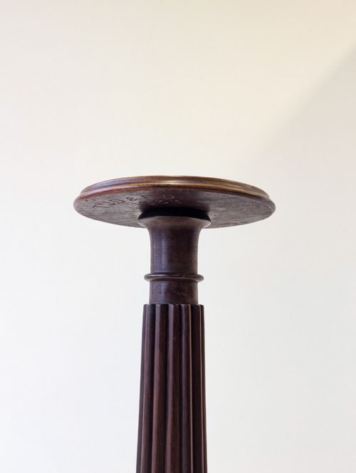 fig 1. A tall William IV dark mahogany torchere featuring a circular moulded top, a reeded turned column stem, and a tripod base with carved legs.