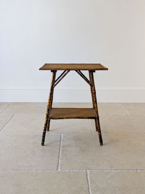 fig 1. An antique Victorian bamboo occasional table featuring a rectangular woven rattan top, a lower tier shelf, and splayed mottled bamboo legs.