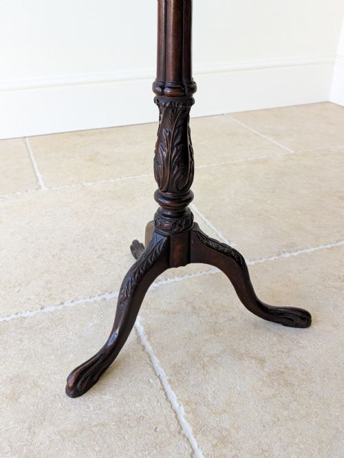 fig 2. A dark mahogany tripod wine table with a circular top, turned carved column stem, and three cabriole legs.