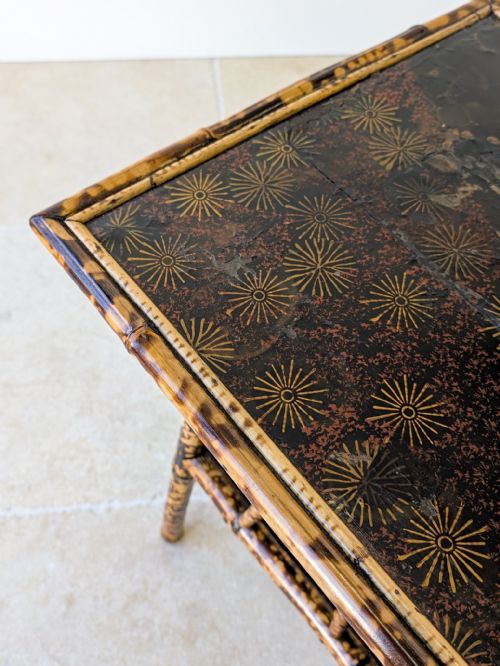fig 2. A late 19th-century square bamboo occasional table featuring a dark lacquered top, a lower tier shelf, and a mottled tortoiseshell finish.