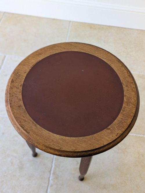 fig 1. An Edwardian dark oak circular occasional table featuring four tapered legs joined by an X-frame cross stretcher.