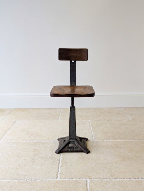 fig 2. An early 20th-century Singer machinist chair featuring an embossed cast iron base, threaded height adjustment screw, and shaped elm timber seat and backrest.