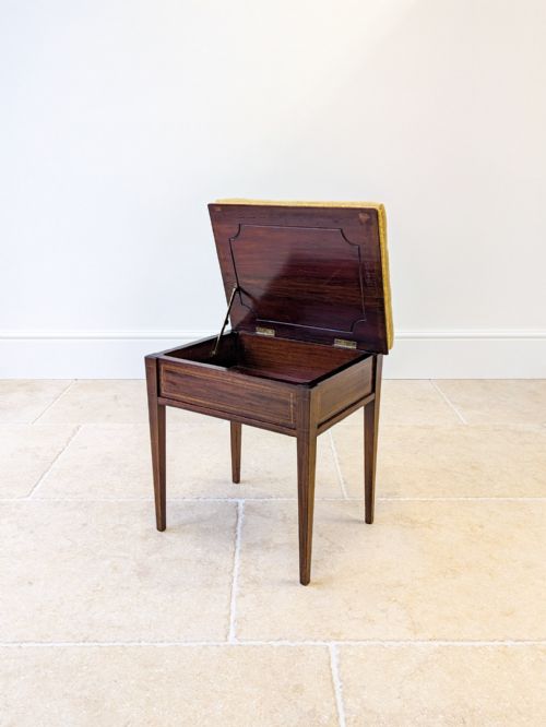 fig 1. An Edwardian dark mahogany piano stool featuring tapered square legs, boxwood stringing inlay, and a floral needlepoint upholstered seat.