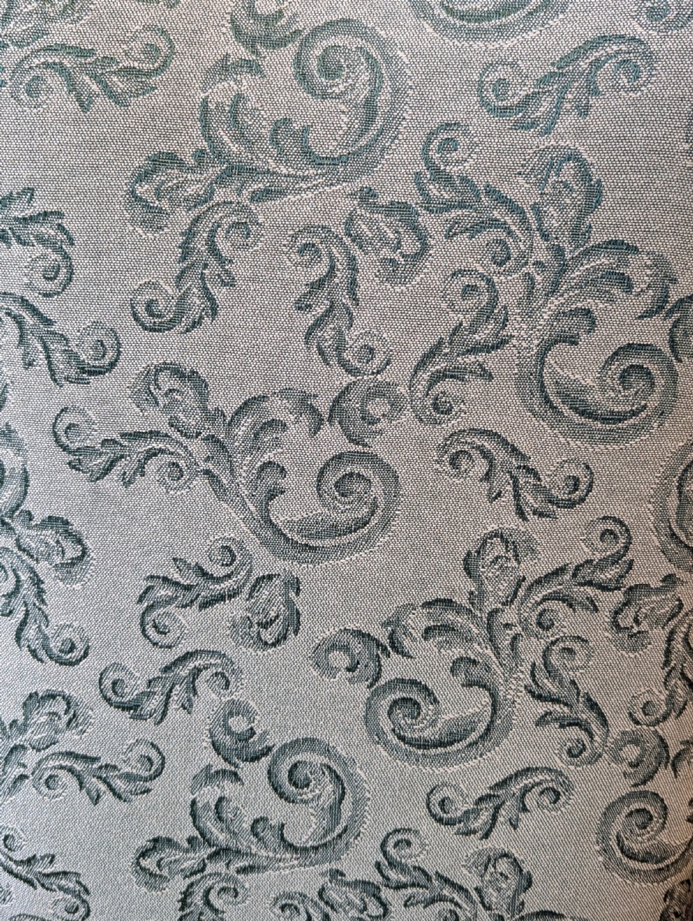An antique Victorian mahogany easy chair upholstered in patterned teal fabric with carved wooden details and turned front legs. View VIII