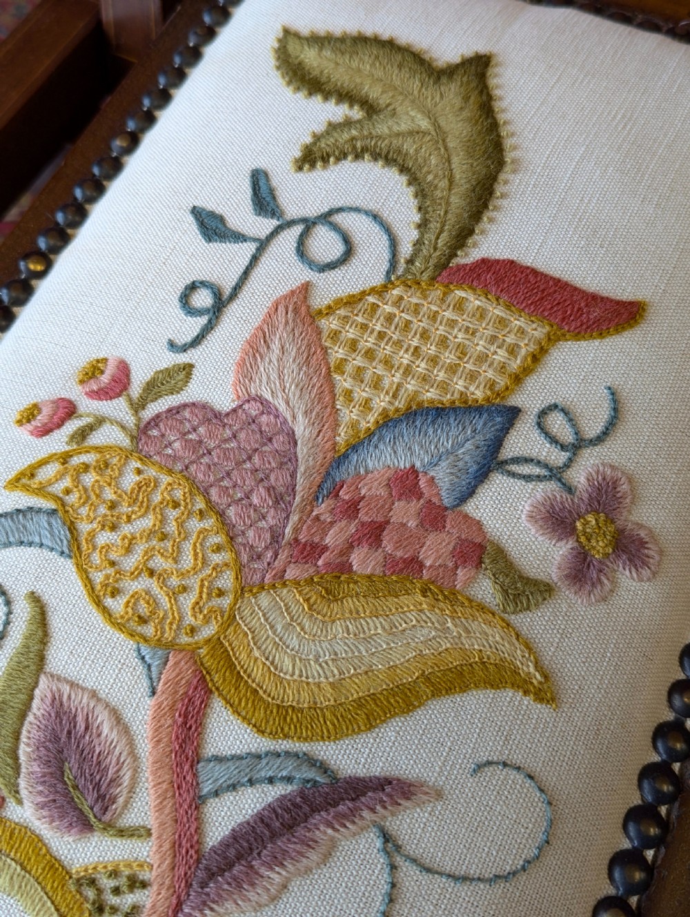 An antique Edwardian folding campaign chair made of mahogany featuring marquetry inlay and an upholstered seat pad. View II