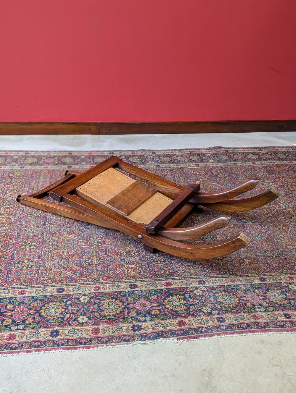 An antique Edwardian folding campaign chair made of mahogany featuring marquetry inlay and an upholstered seat pad. View VII