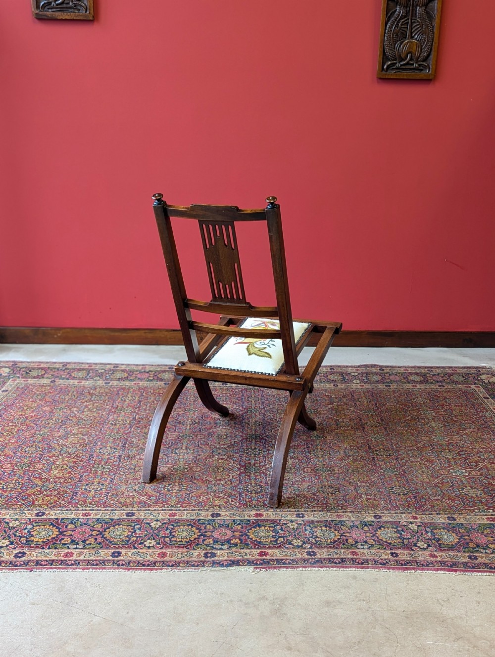 An antique Edwardian folding campaign chair made of mahogany featuring marquetry inlay and an upholstered seat pad. View VIII