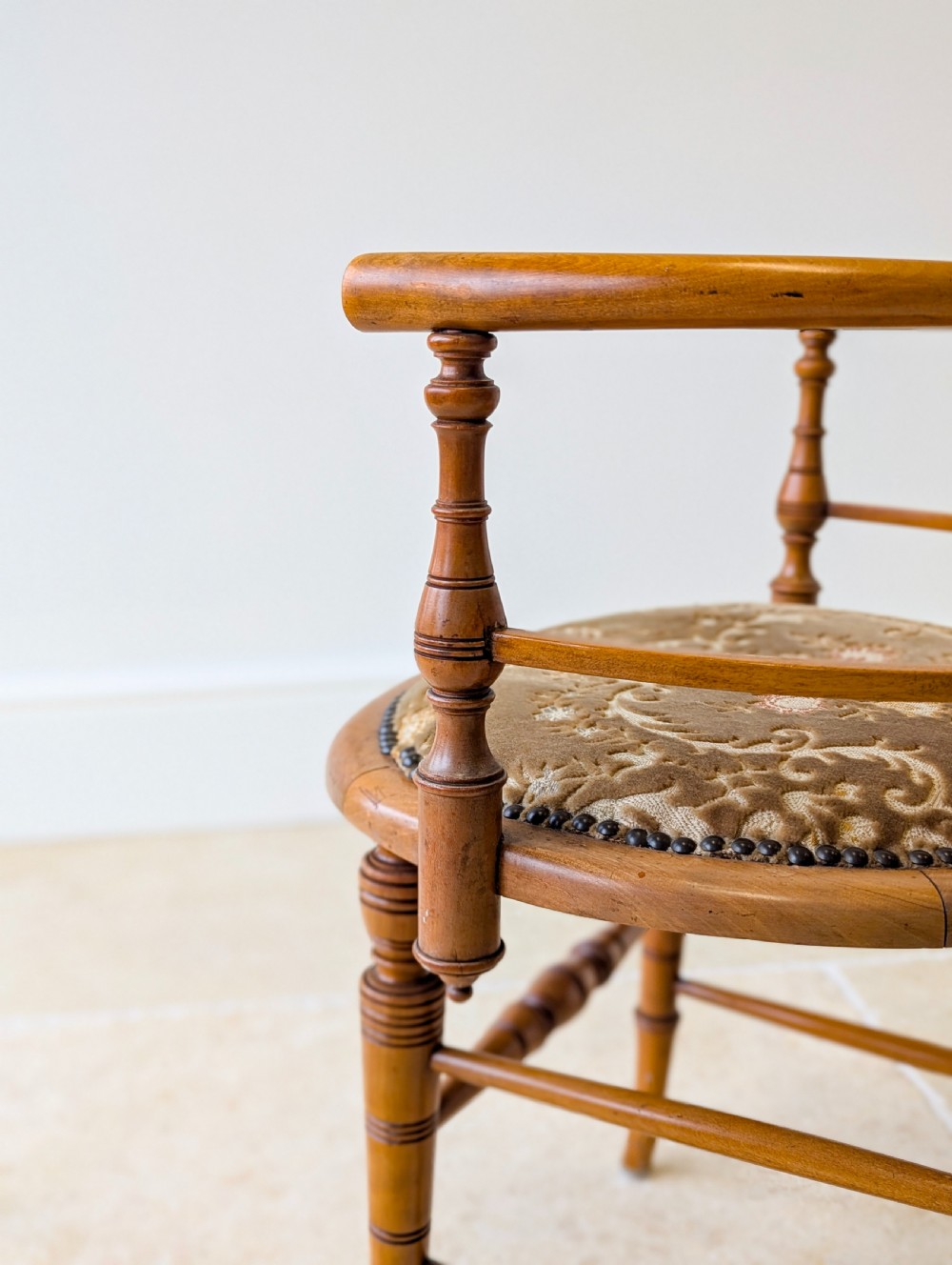 A late Victorian satinwood elbow chair featuring a lyre-shaped backrest with a painted central medallion, turned front legs, and an upholstered seat. View XVI