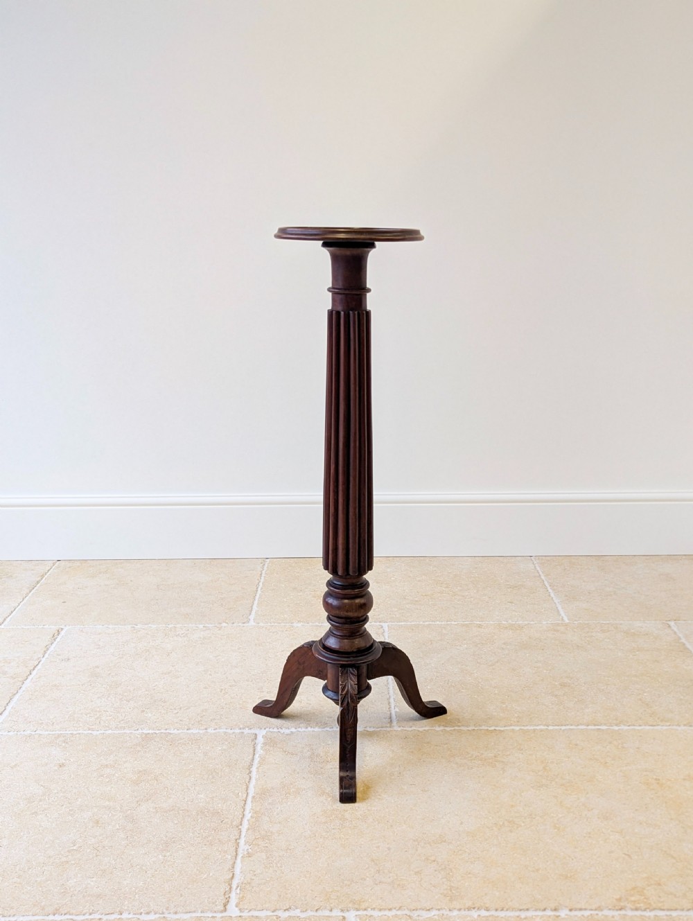 A dark mahogany William IV torchere stand featuring a fluted column shaft resting on a turned tripod base. View X