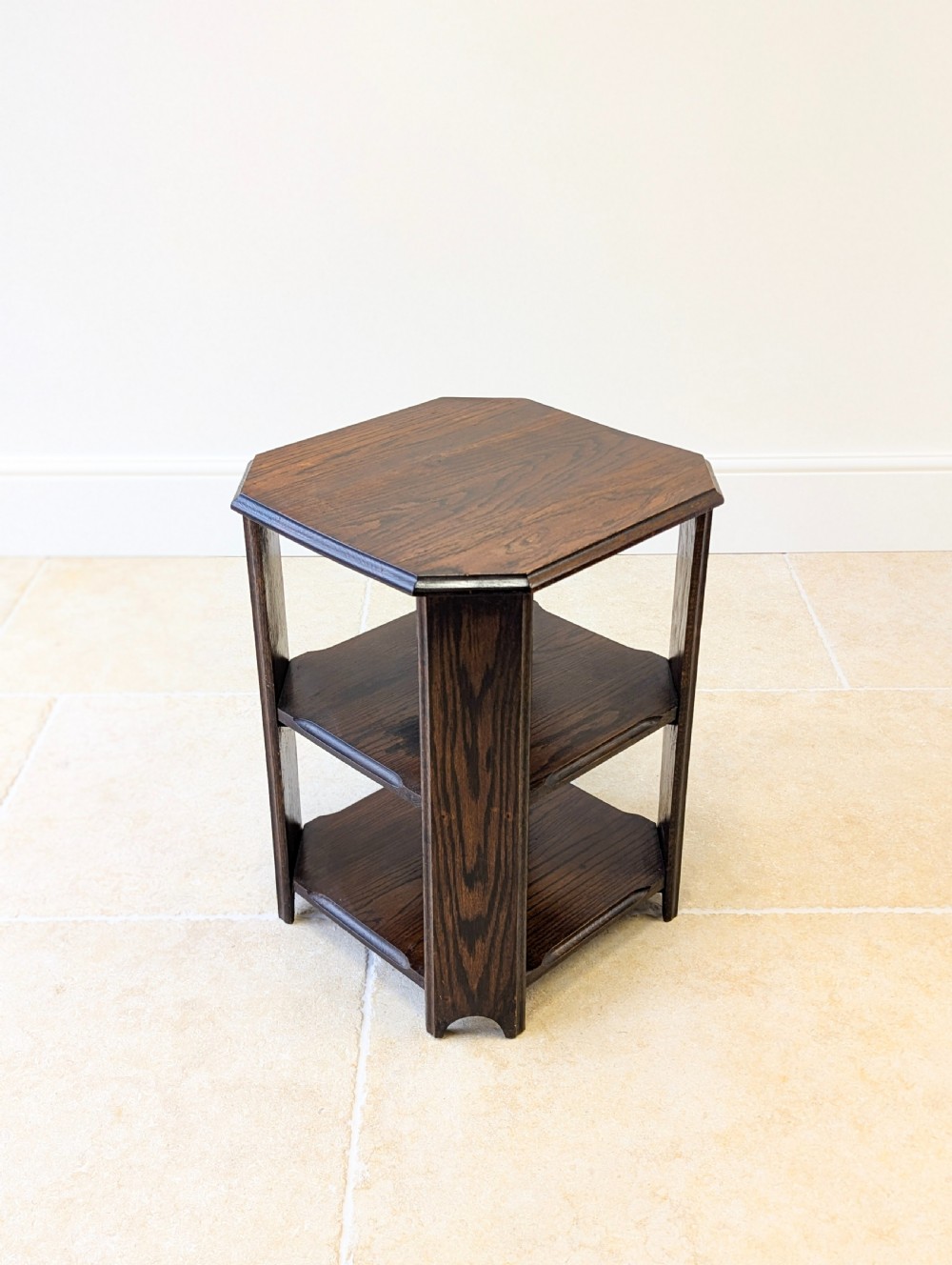 A dark brown oak book table with clipped corners on top and two open lower shelves supported by straight side legs. View II