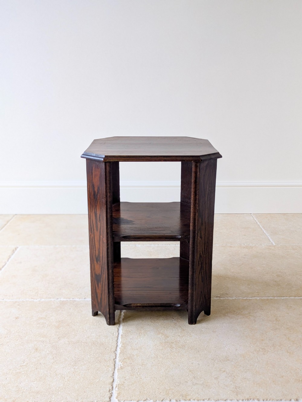 A dark brown oak book table with clipped corners on top and two open lower shelves supported by straight side legs. View VIII