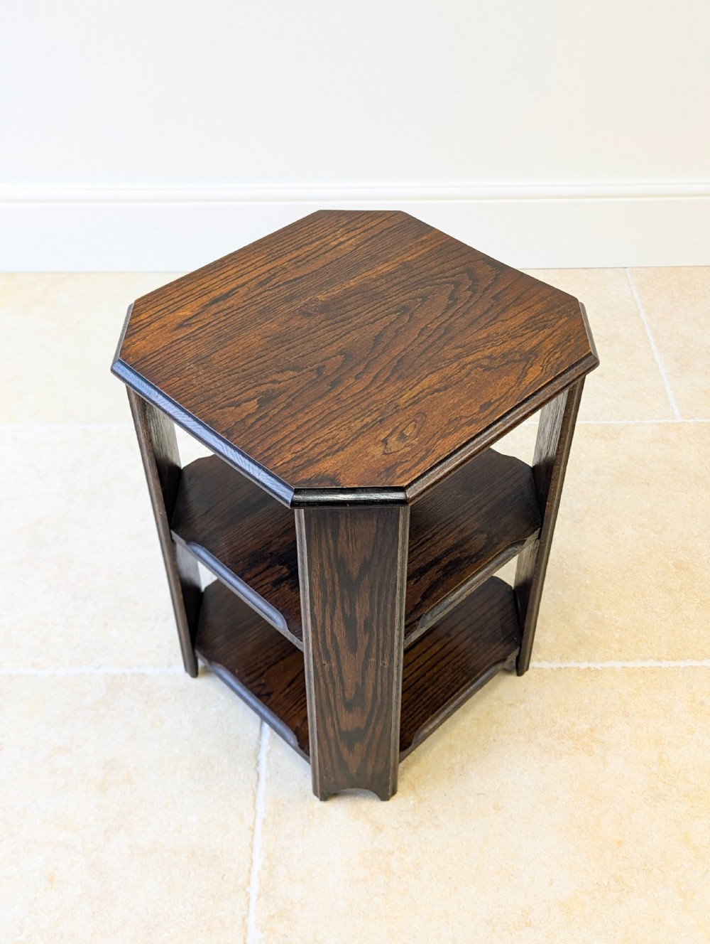 A dark brown oak book table with clipped corners on top and two open lower shelves supported by straight side legs. View XIII