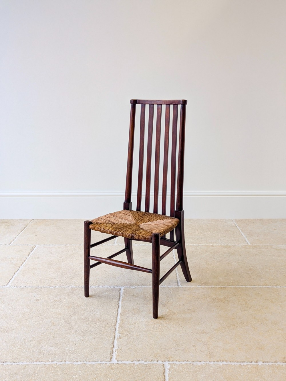 An Arts and Crafts dark mahogany side chair featuring a tall vertical slat backrest, a woven rush seat, and simple turned legs with stretchers. View VIII
