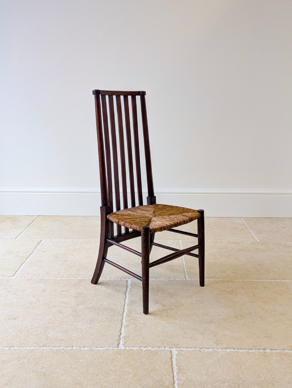 An Arts and Crafts dark mahogany side chair featuring a tall vertical slat backrest, a woven rush seat, and simple turned legs with stretchers. View XIII