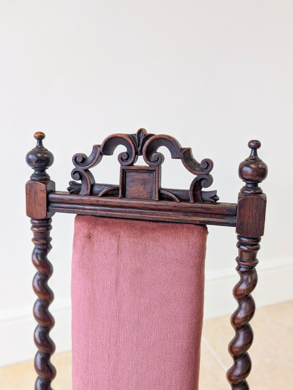 A Victorian rosewood side chair featuring barley twist legs and uprights, a carved cresting rail, dusty pink velvet upholstery, and brass castors. View VIII