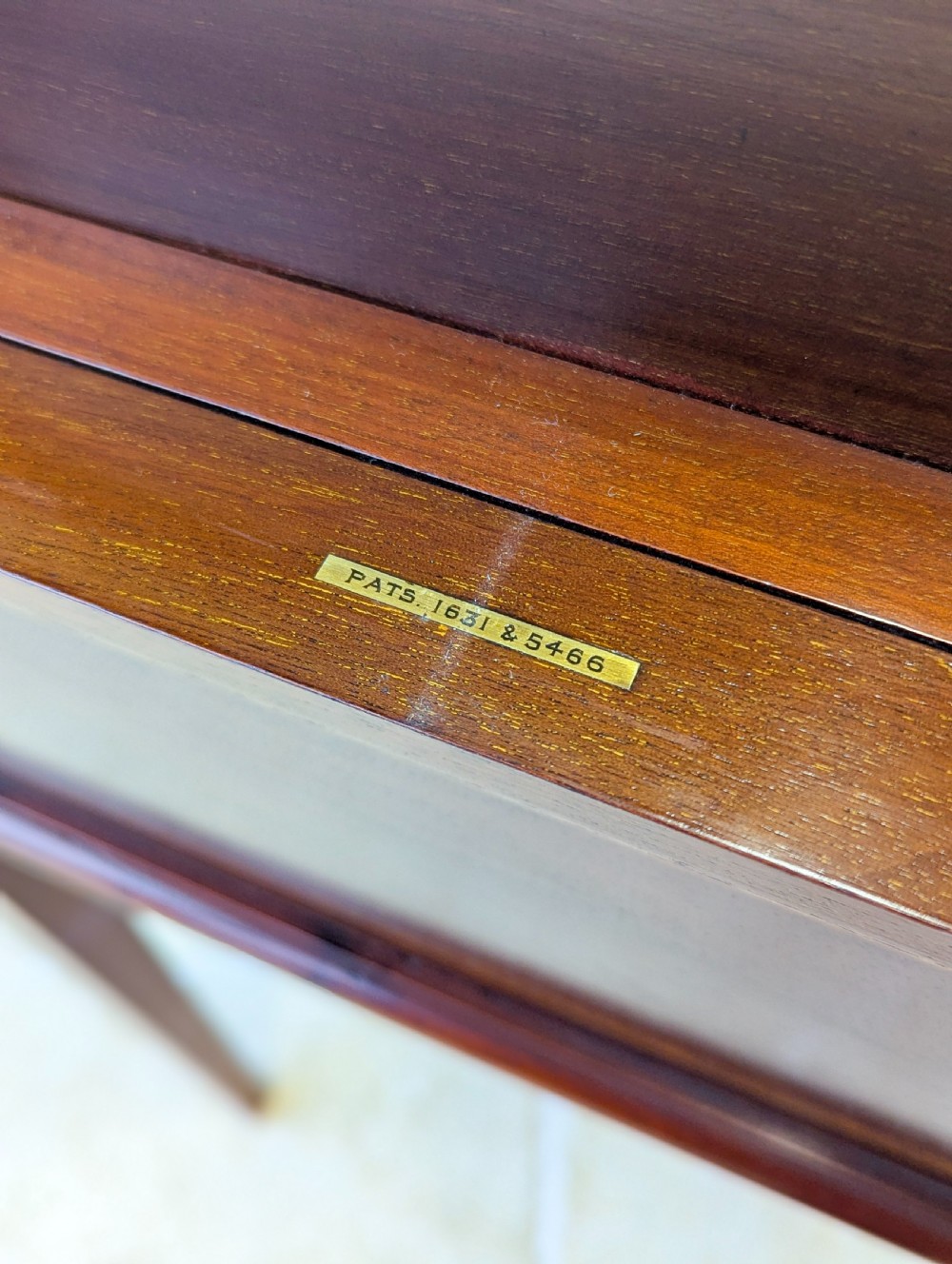 An Edwardian dark mahogany metamorphic writing table featuring two hinged side flaps, a sloped leather writing surface, integrated stationery dividers, and tapered legs. View XV