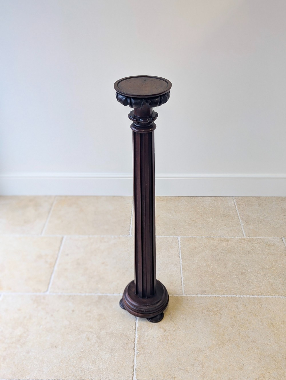 A tall Victorian dark mahogany torchere stand featuring a carved fluted column shaft, gadrooned top rim, and a circular moulded base. View III