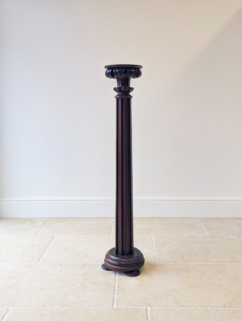 A tall Victorian dark mahogany torchere stand featuring a carved fluted column shaft, gadrooned top rim, and a circular moulded base. View XI