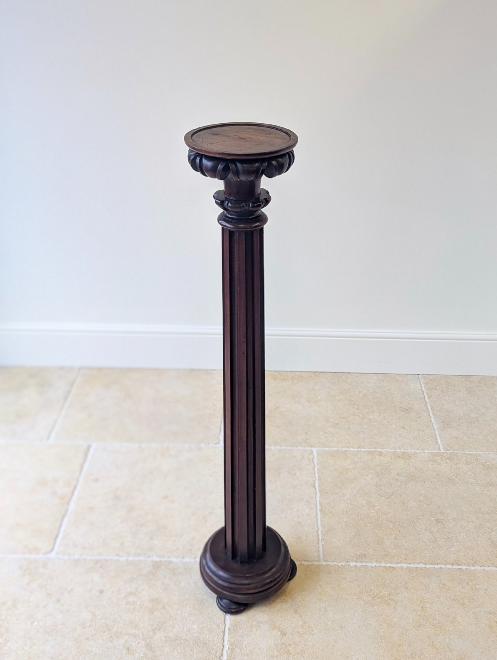 A tall Victorian dark mahogany torchere stand featuring a carved fluted column shaft, gadrooned top rim, and a circular moulded base. View XIII