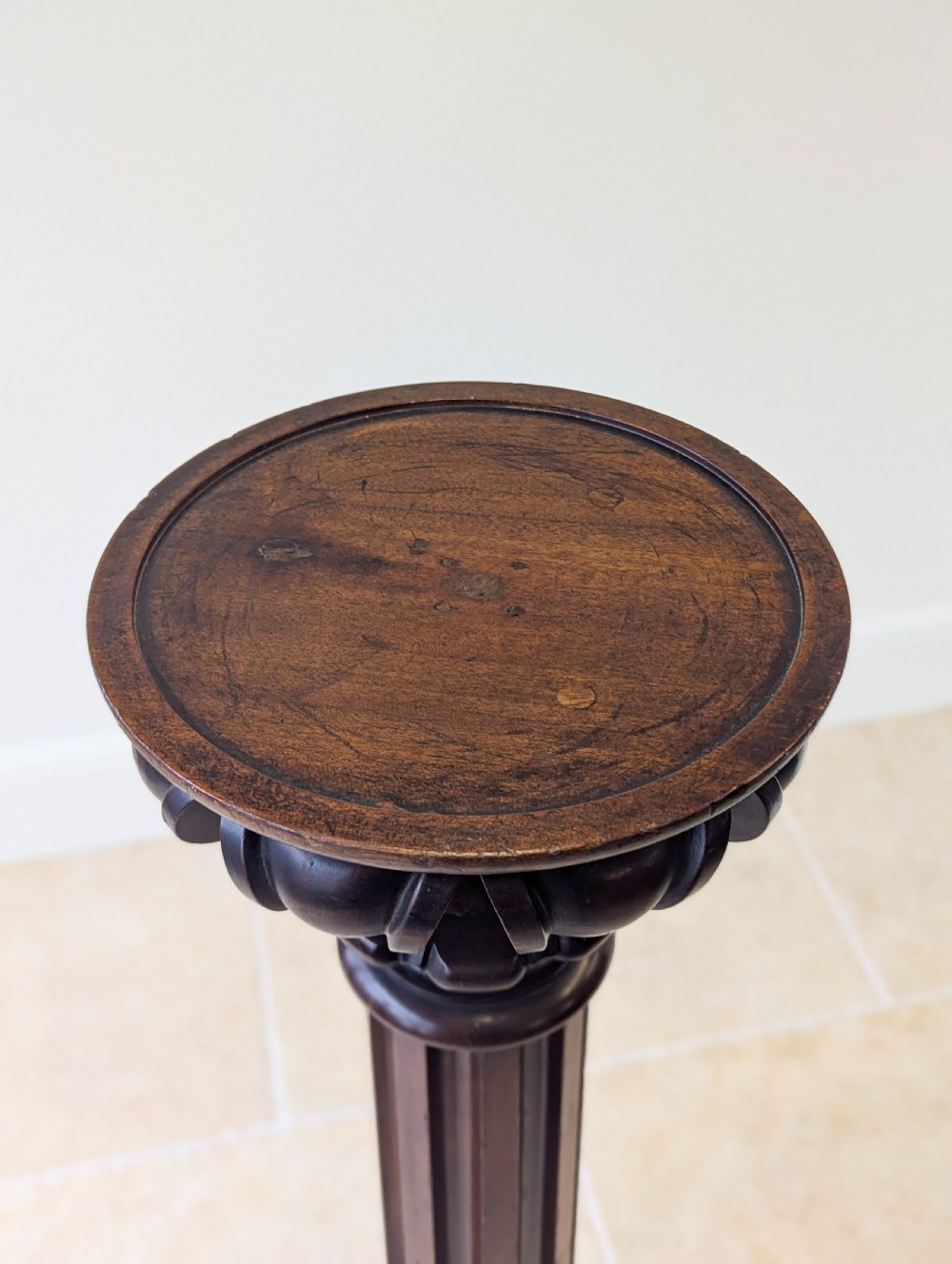 A tall Victorian dark mahogany torchere stand featuring a carved fluted column shaft, gadrooned top rim, and a circular moulded base. View XIV