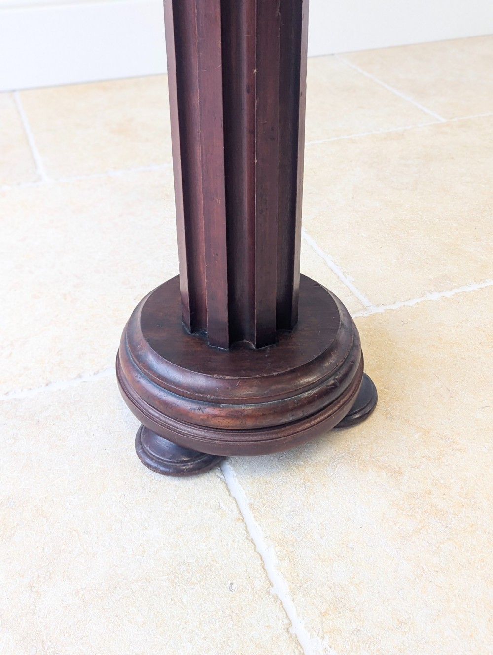 A tall Victorian dark mahogany torchere stand featuring a carved fluted column shaft, gadrooned top rim, and a circular moulded base. View XV