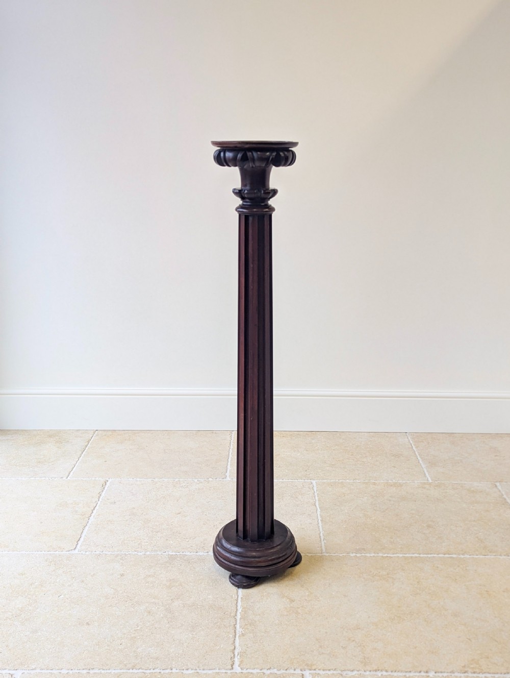 A tall Victorian dark mahogany torchere stand featuring a carved fluted column shaft, gadrooned top rim, and a circular moulded base. View XVI