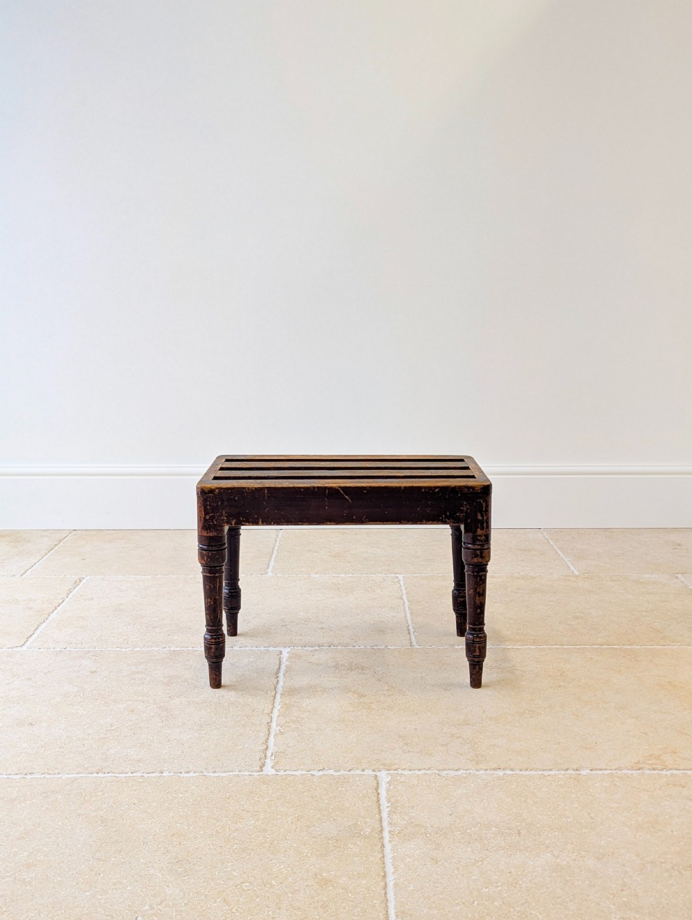 An antique Victorian dark stained beech luggage stand featuring a slatted top and four turned legs. View II