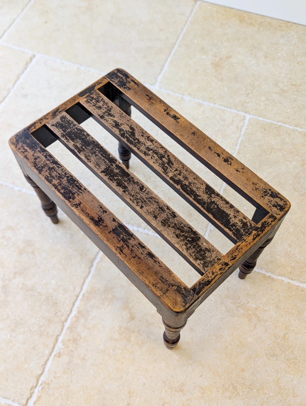 An antique Victorian dark stained beech luggage stand featuring a slatted top and four turned legs. View III