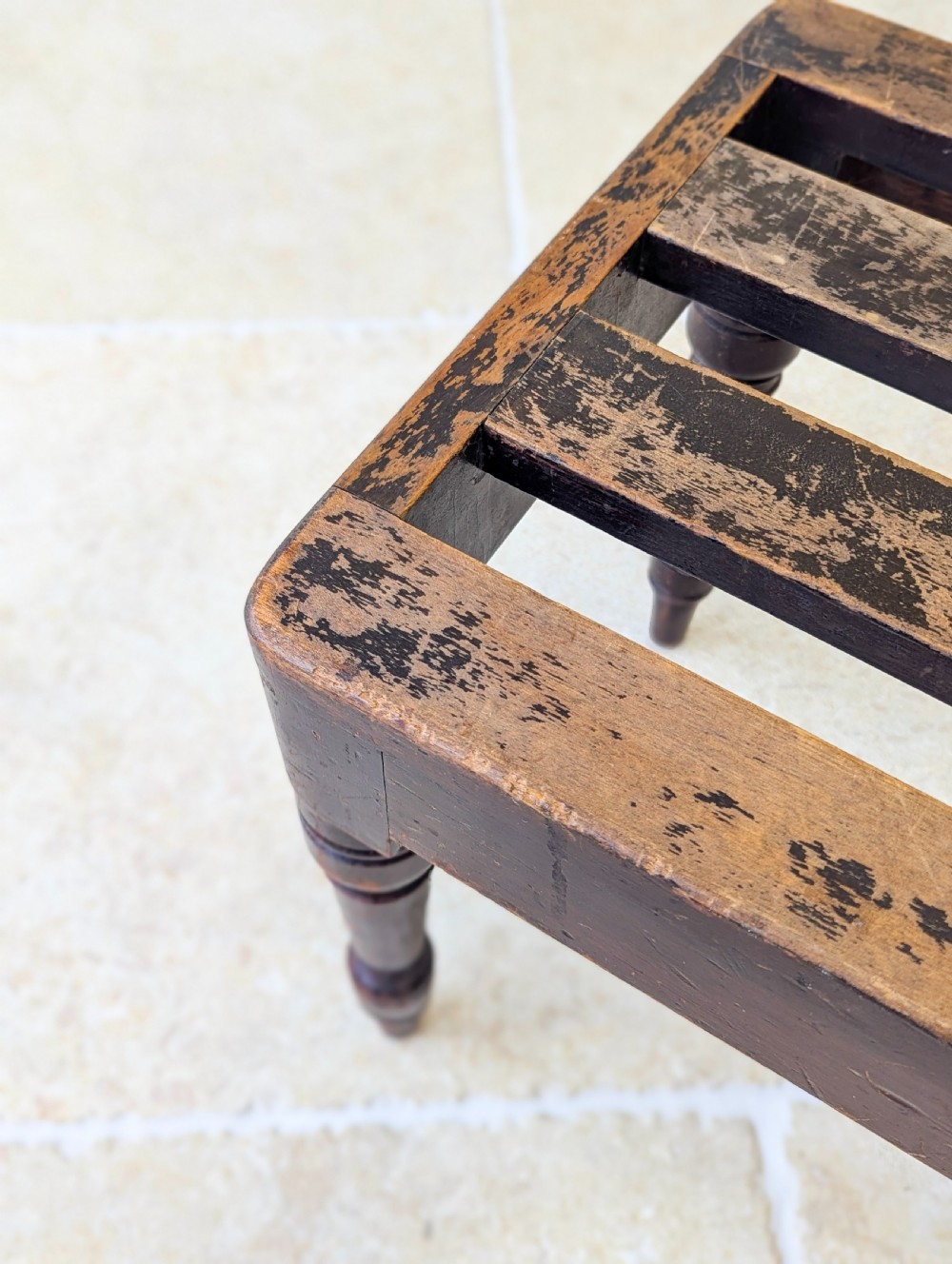 An antique Victorian dark stained beech luggage stand featuring a slatted top and four turned legs. View V