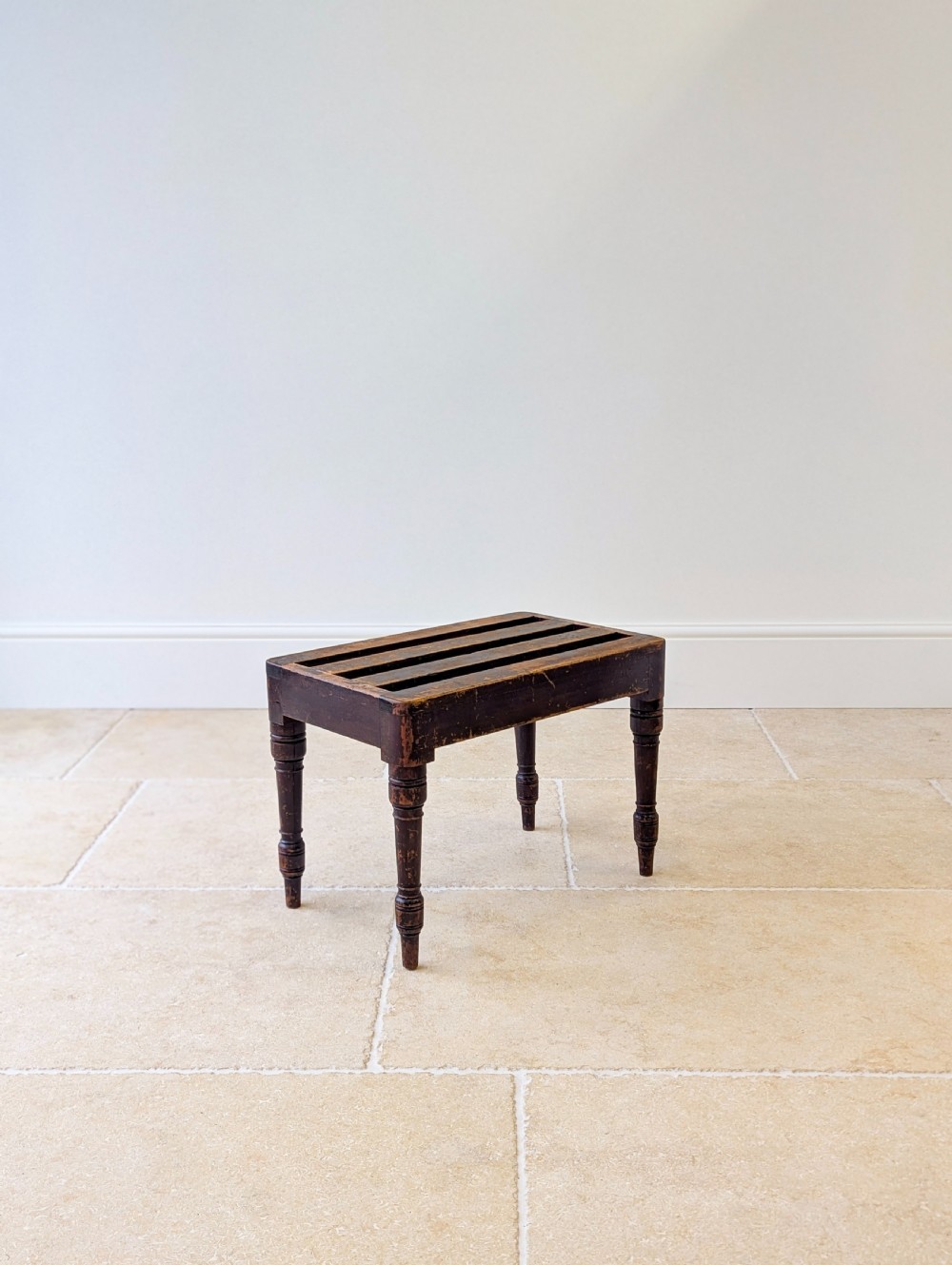 An antique Victorian dark stained beech luggage stand featuring a slatted top and four turned legs. View VIII