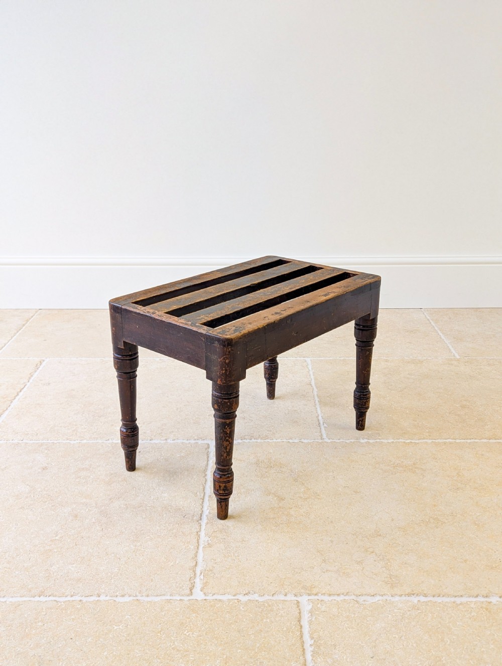 An antique Victorian dark stained beech luggage stand featuring a slatted top and four turned legs. View XIII