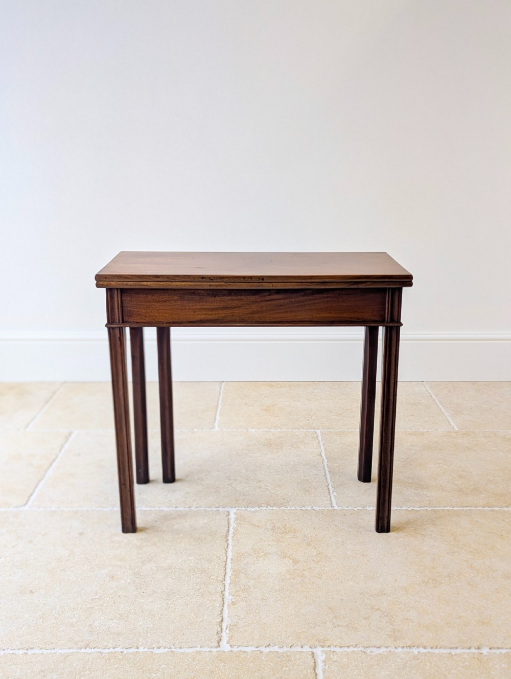 A late 18th-century dark mahogany fold-over tea table featuring reeded straight legs and a polished hinged top. View III