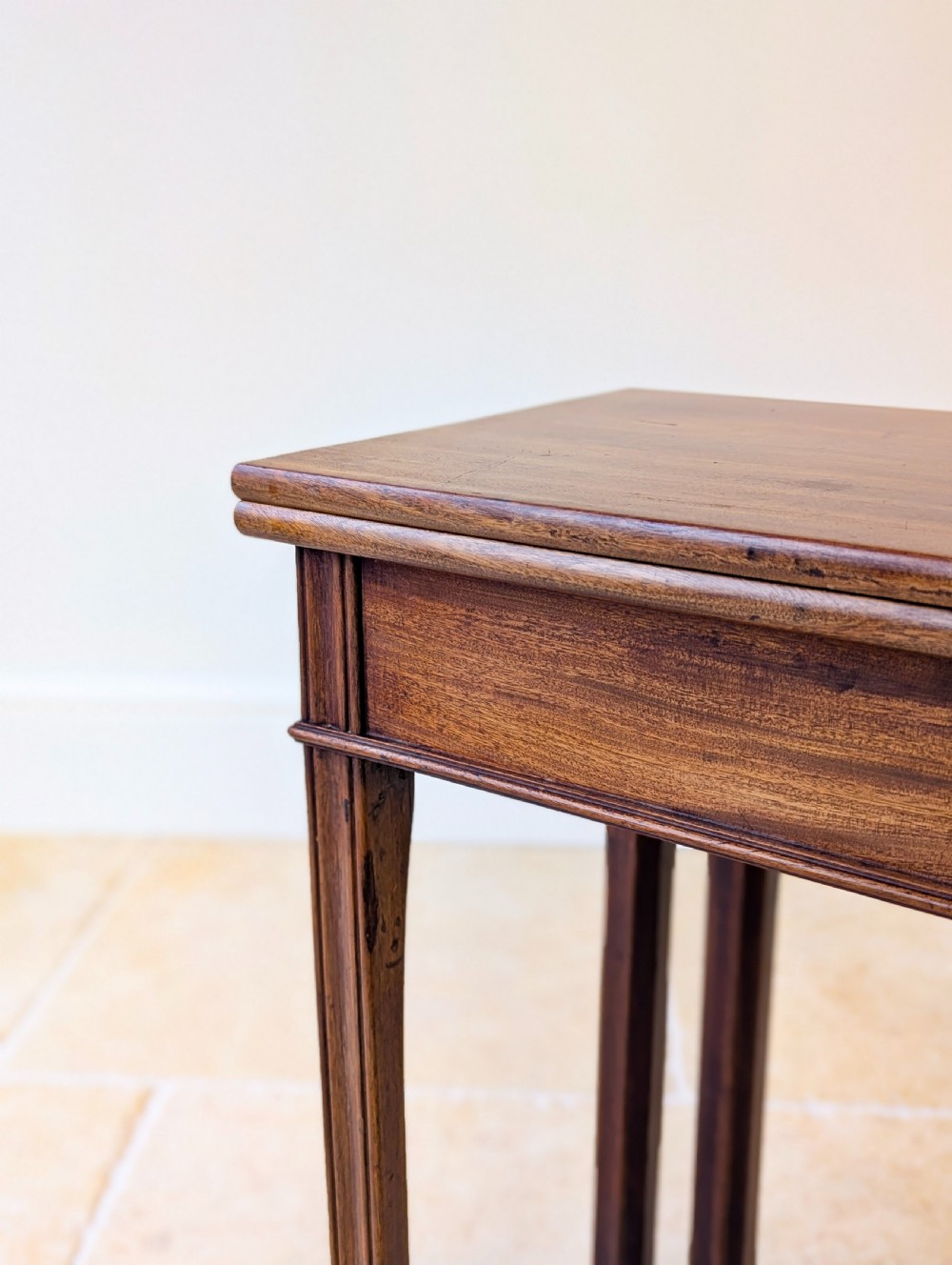 A late 18th-century dark mahogany fold-over tea table featuring reeded straight legs and a polished hinged top. View IV