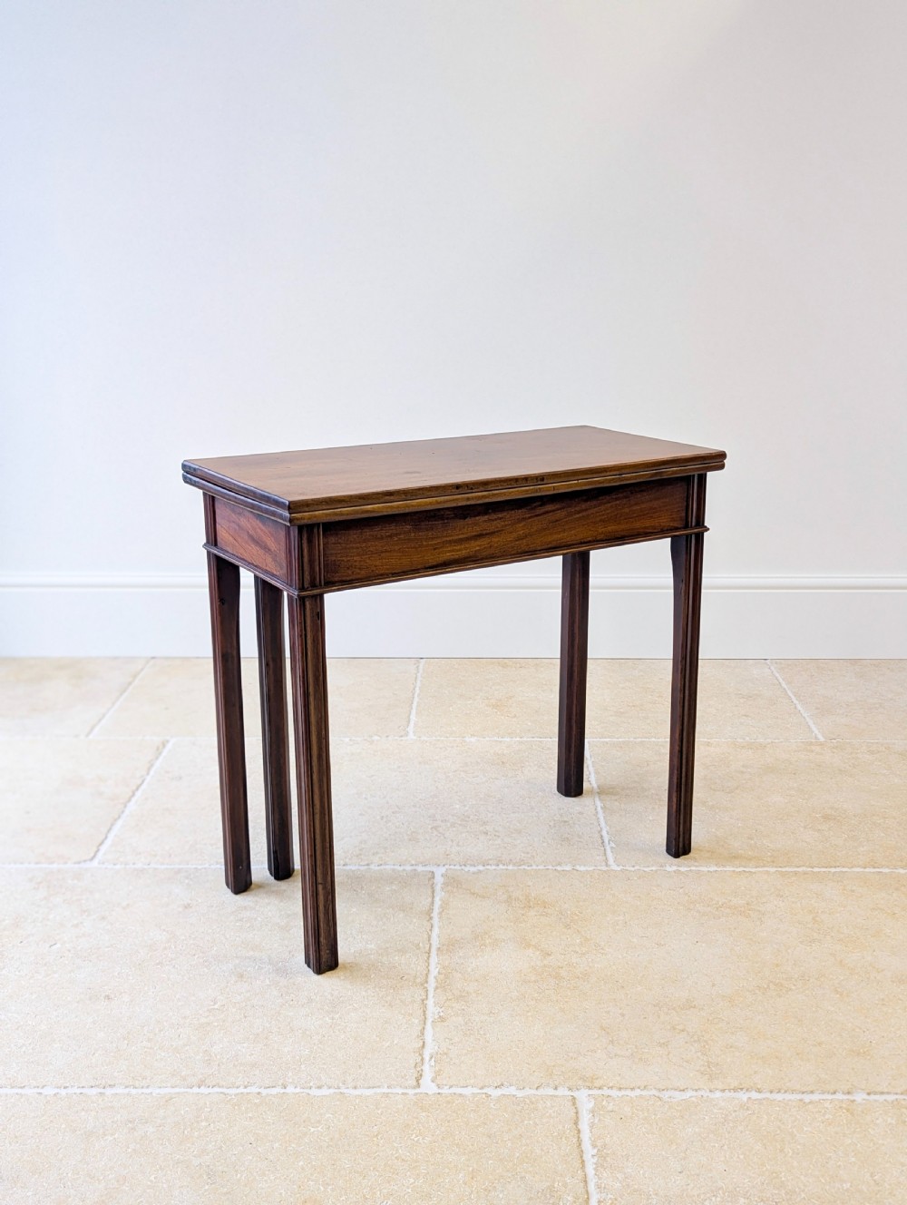 A late 18th-century dark mahogany fold-over tea table featuring reeded straight legs and a polished hinged top. View VI