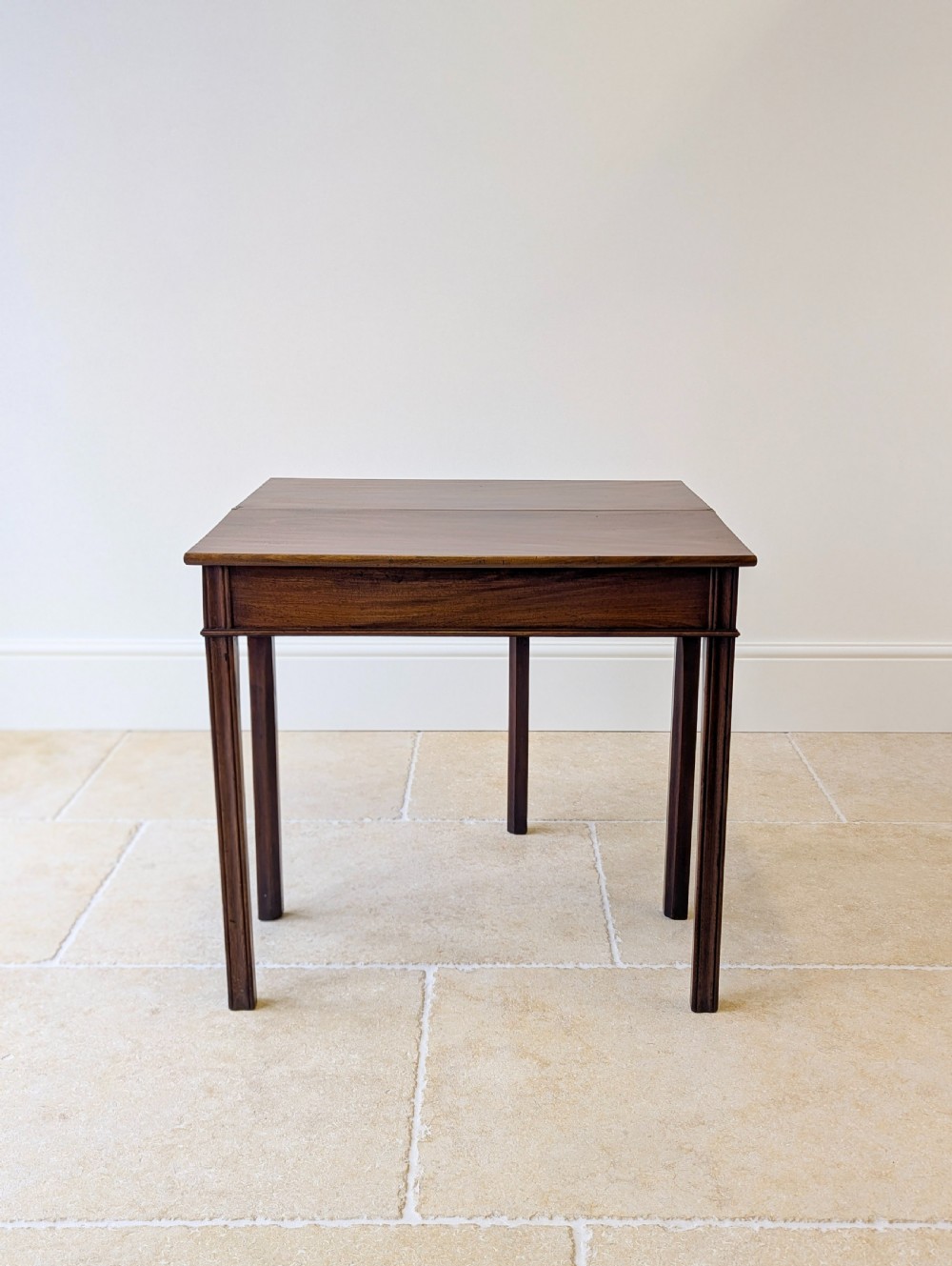 A late 18th-century dark mahogany fold-over tea table featuring reeded straight legs and a polished hinged top. View VII