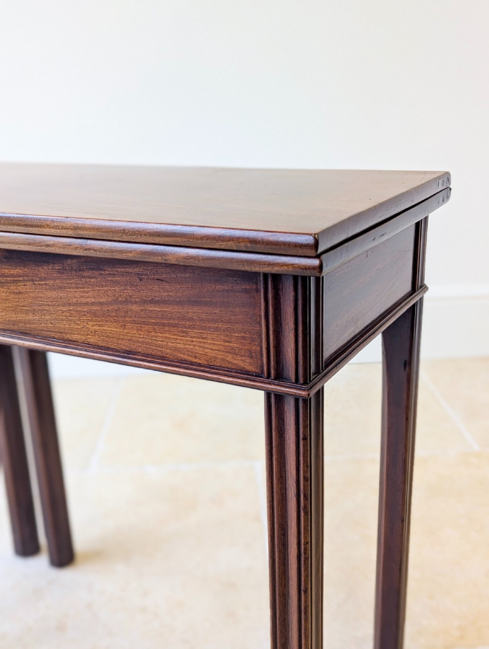 A late 18th-century dark mahogany fold-over tea table featuring reeded straight legs and a polished hinged top. View VIII