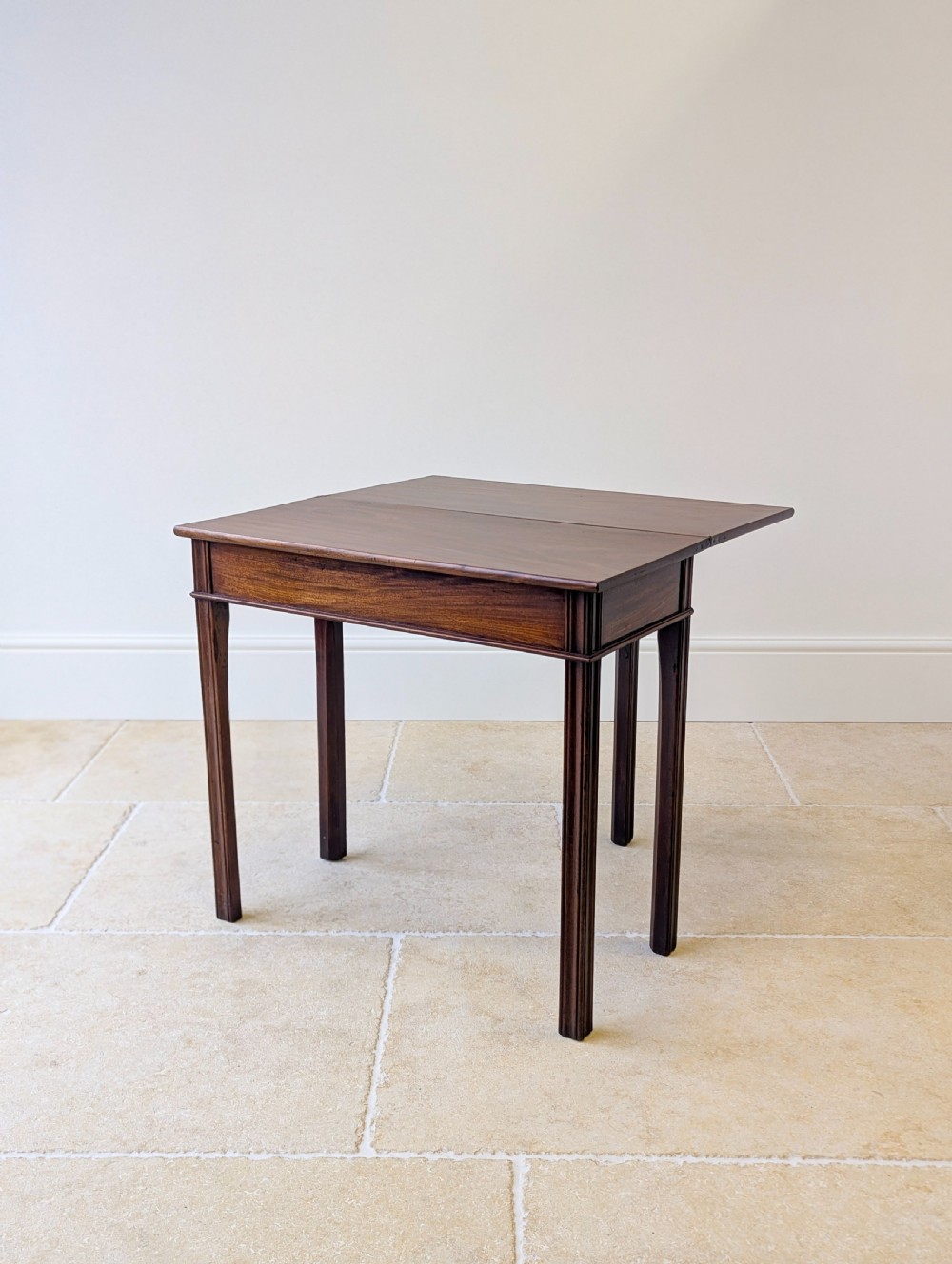A late 18th-century dark mahogany fold-over tea table featuring reeded straight legs and a polished hinged top. View IX