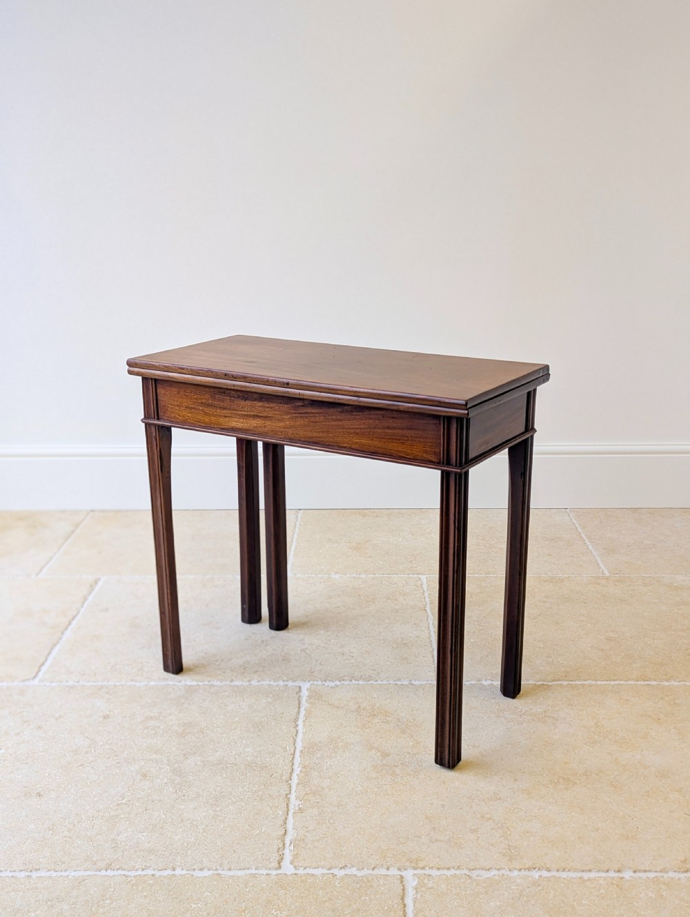 A late 18th-century dark mahogany fold-over tea table featuring reeded straight legs and a polished hinged top. View XI