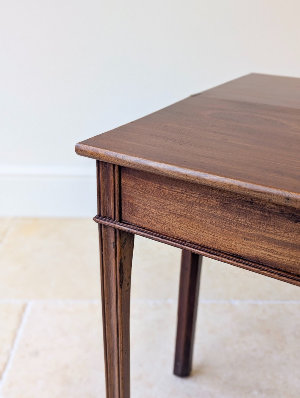 A late 18th-century dark mahogany fold-over tea table featuring reeded straight legs and a polished hinged top. View XII