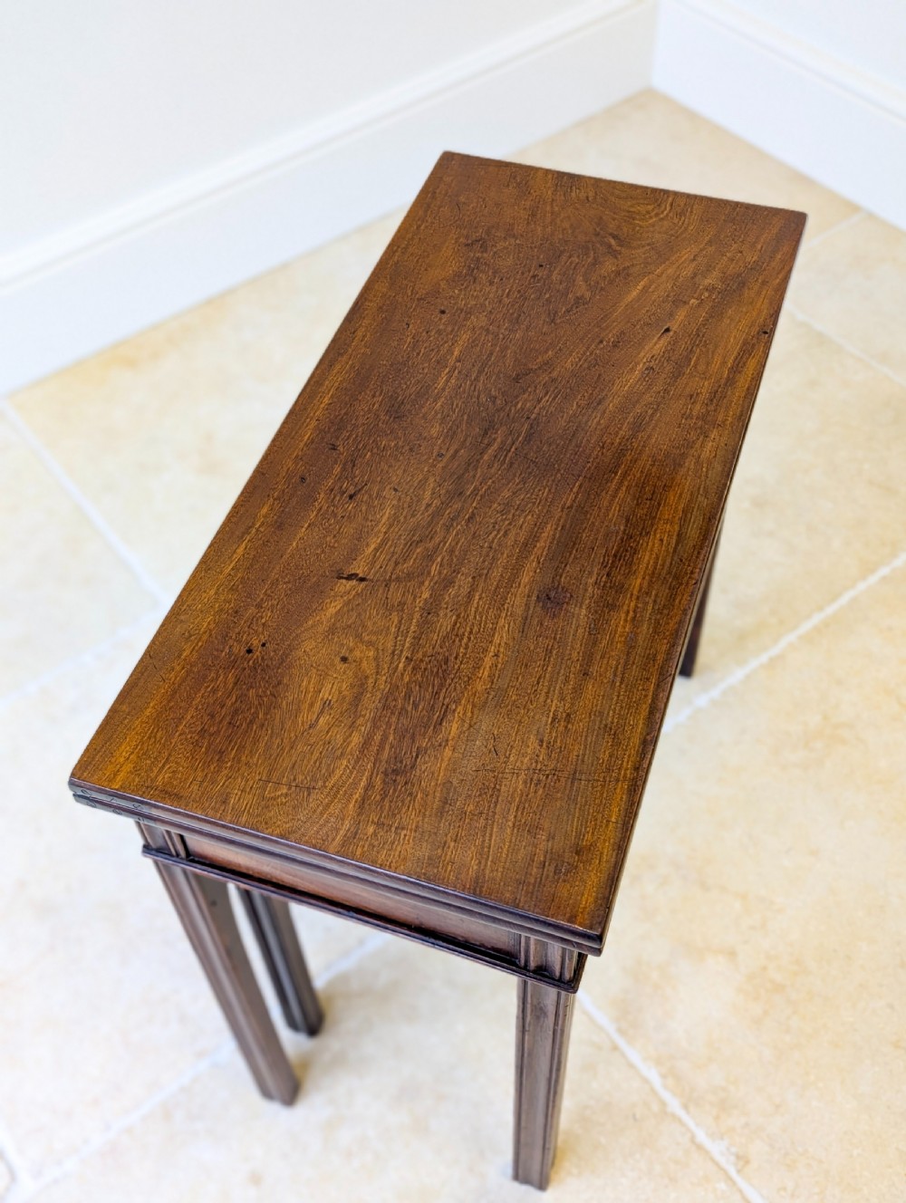 A late 18th-century dark mahogany fold-over tea table featuring reeded straight legs and a polished hinged top. View XIII