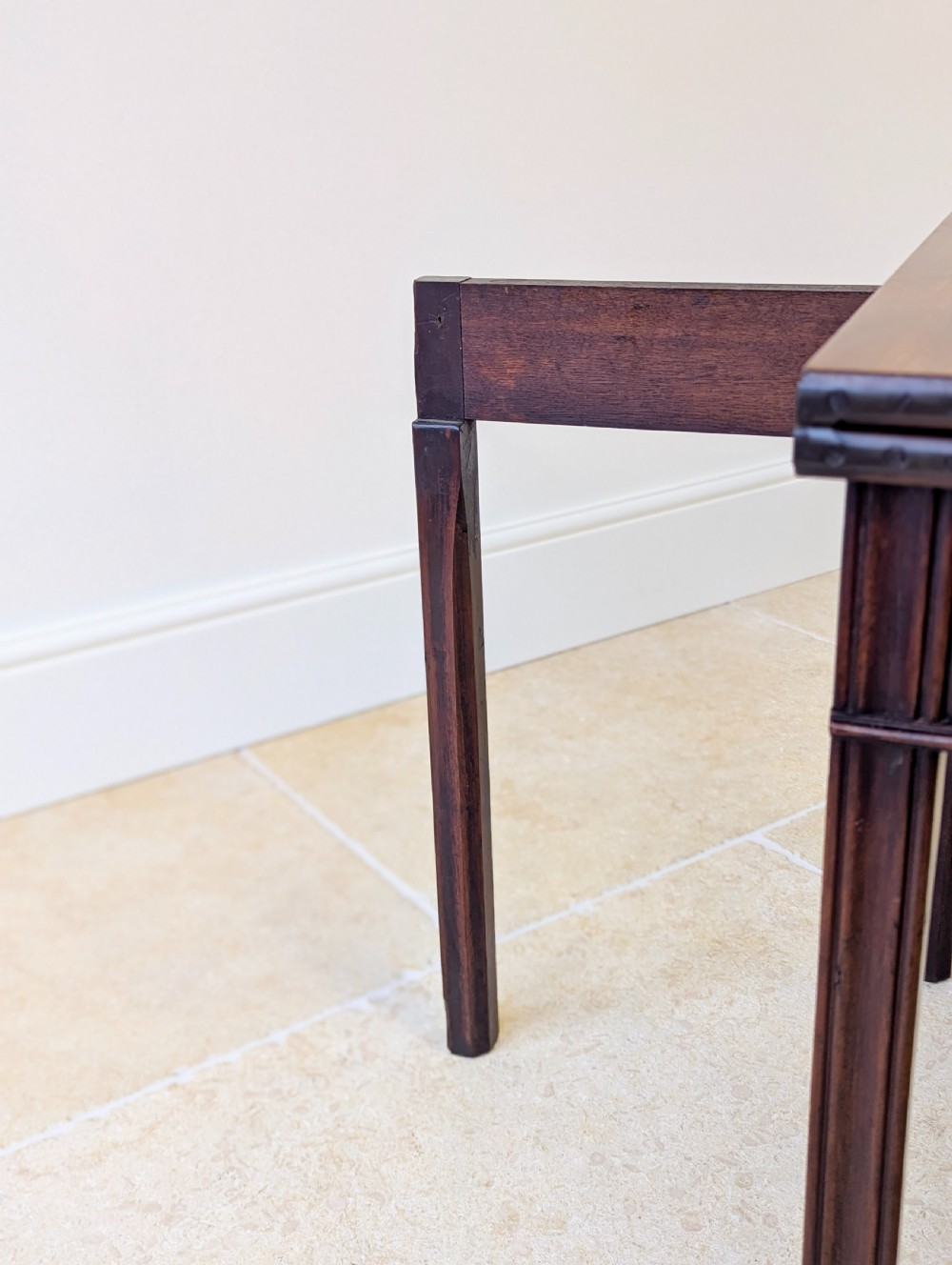 A late 18th-century dark mahogany fold-over tea table featuring reeded straight legs and a polished hinged top. View XVIII