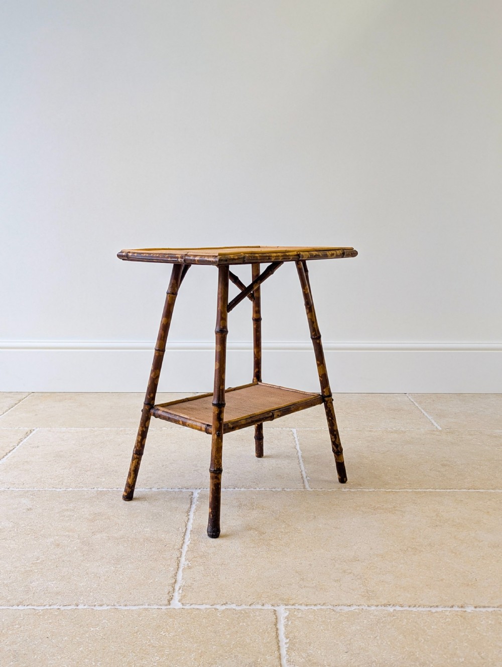 A late Victorian bamboo occasional table featuring a woven cane top surface, lower cane shelf, and splayed mottled bamboo legs. View VIII