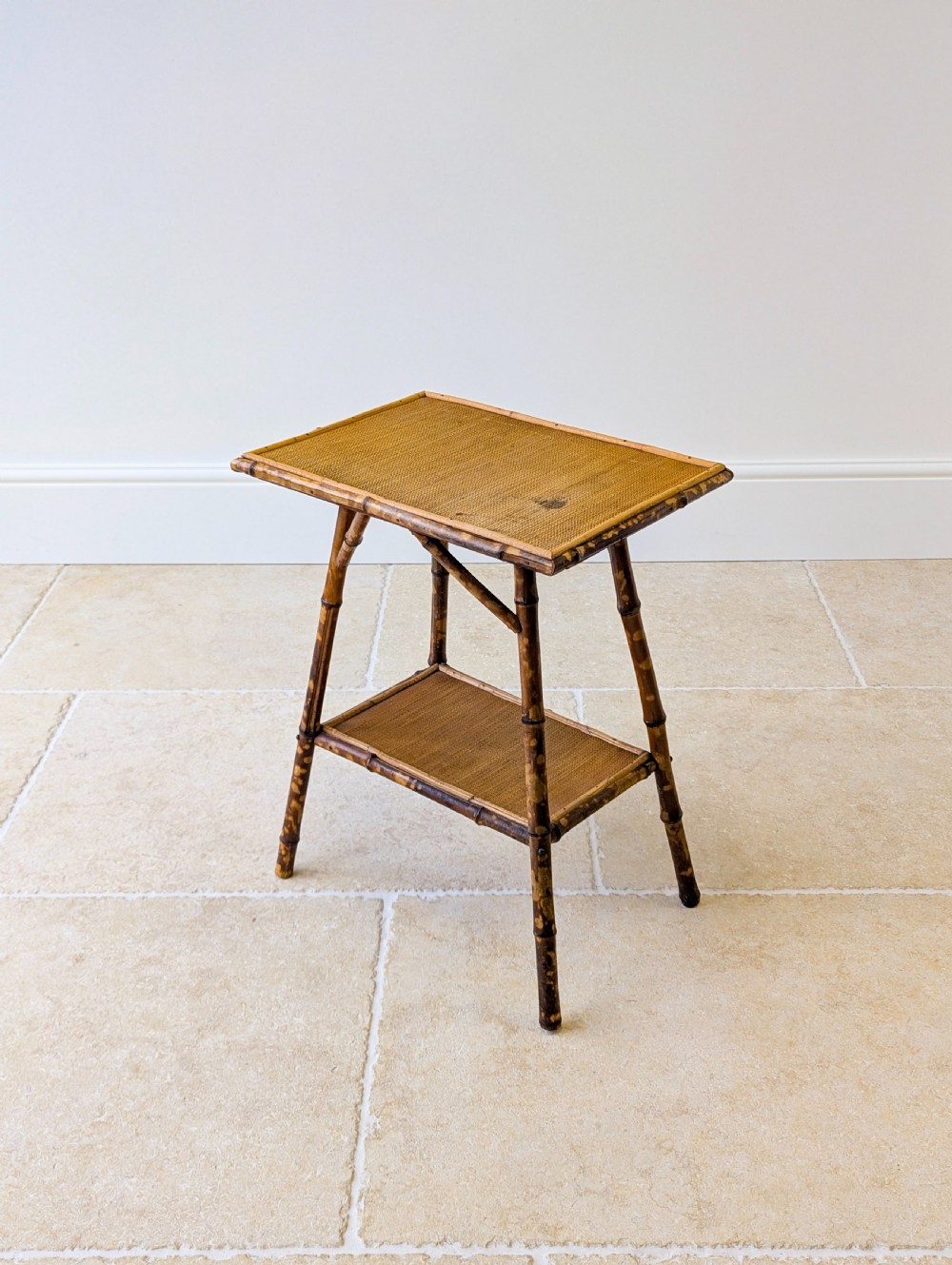 A late Victorian bamboo occasional table featuring a woven cane top surface, lower cane shelf, and splayed mottled bamboo legs. View XI
