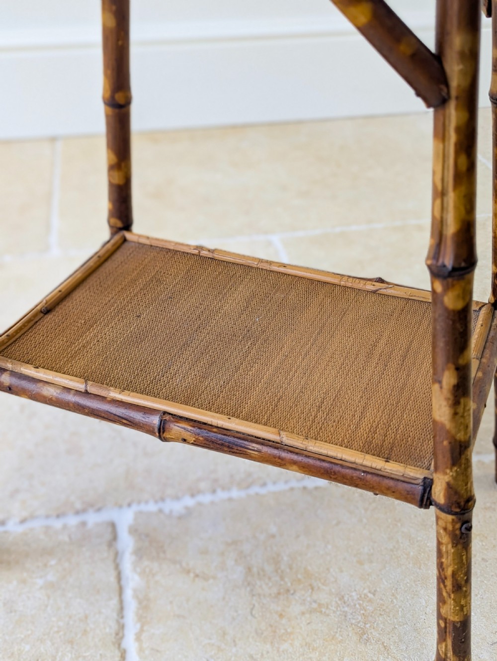 A late Victorian bamboo occasional table featuring a woven cane top surface, lower cane shelf, and splayed mottled bamboo legs. View XII