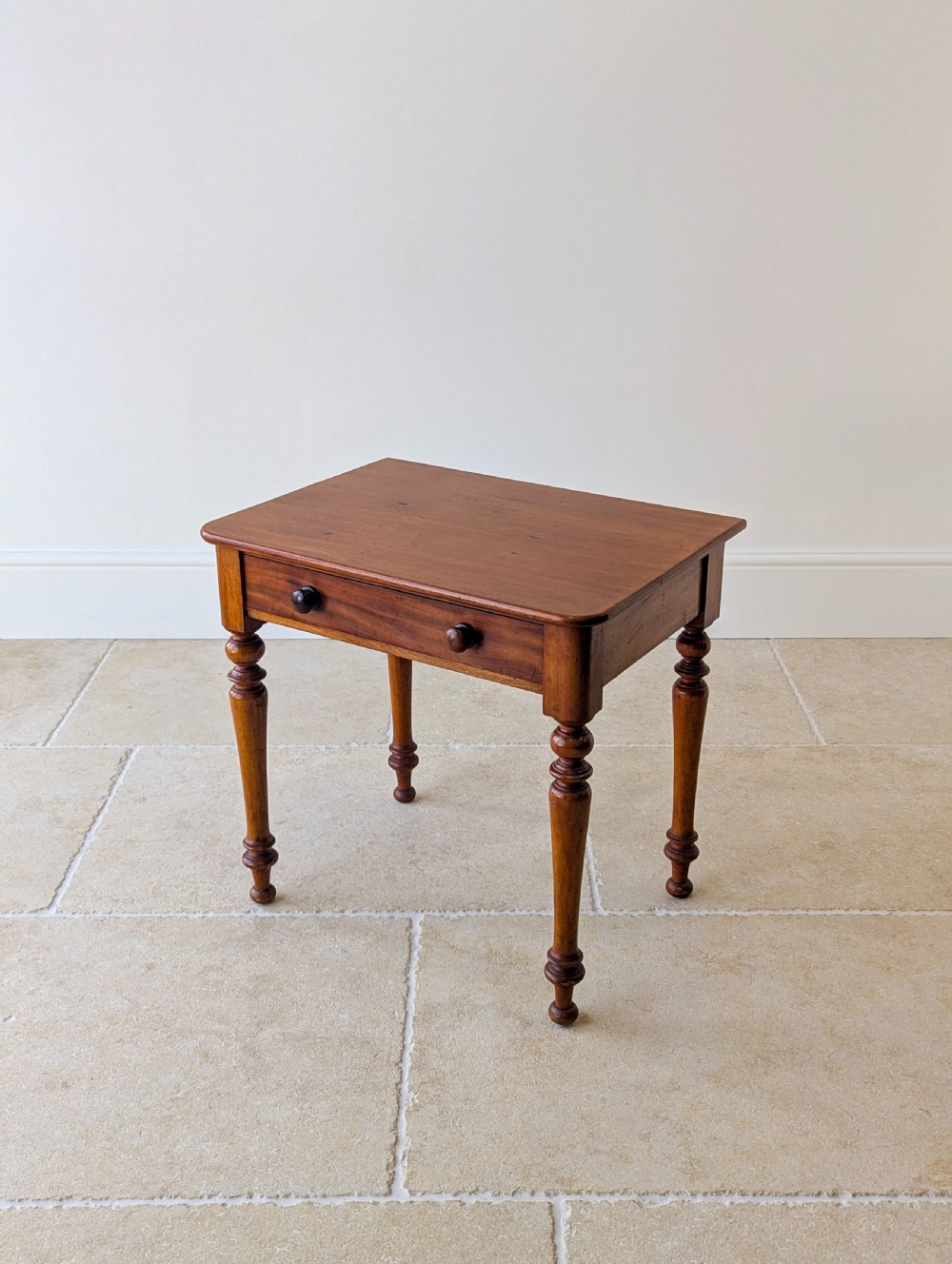 A late Victorian mahogany side table featuring a rectangular top, single drawer with two turned wooden knobs, and four turned legs. View V