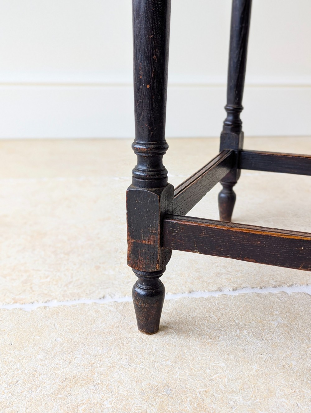 An Edwardian dark oak rectangular occasional table featuring a relief-carved foliate border on the top, slender turned legs, and lower perimeter stretchers. View VIII