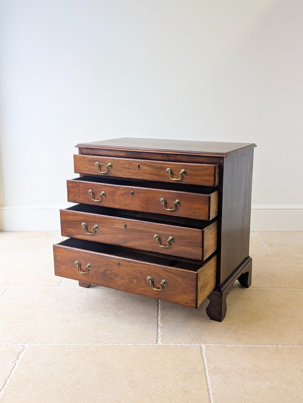 An 18th-century George III mahogany chest of drawers featuring four graduated drawers with brass swan-neck handles and bracket feet. View III