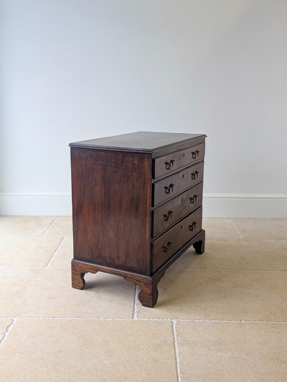 An 18th-century George III mahogany chest of drawers featuring four graduated drawers with brass swan-neck handles and bracket feet. View XIV
